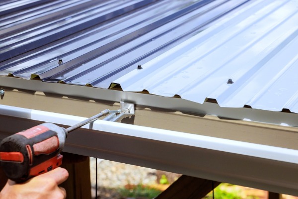 installing rain gutter on corrugated metal roof